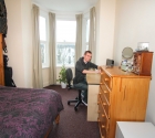 Plymouth university flatmate studying in student bedroom at desk.