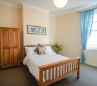 Large double bedroom with wooden furniture in plymouth uni house.