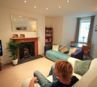 Happy housemate watching tv in homely living room in his plymouth university shared house.