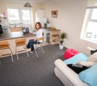 Plymouth University student smiling in open plan kitchen.